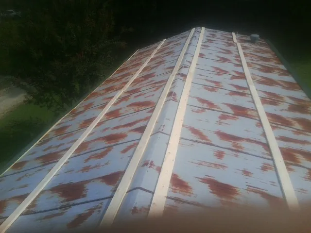 Rusted metal roof panels with new wood purlins before replacement — Storm Damage Roof Repair in Comer by Roofing Brothers